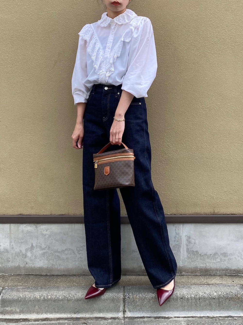 ブルー系のデニムパンツ、ブラウン系のバッグ、レッド系のパンプスを着用したレディースの夏コーディネートの4枚目の写真