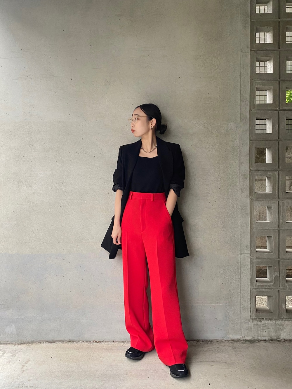 ブラック系のテーラードジャケット、レッド系のその他パンツ、ベージュ系のメガネを着用したレディースの春コーディネートの2枚目の写真