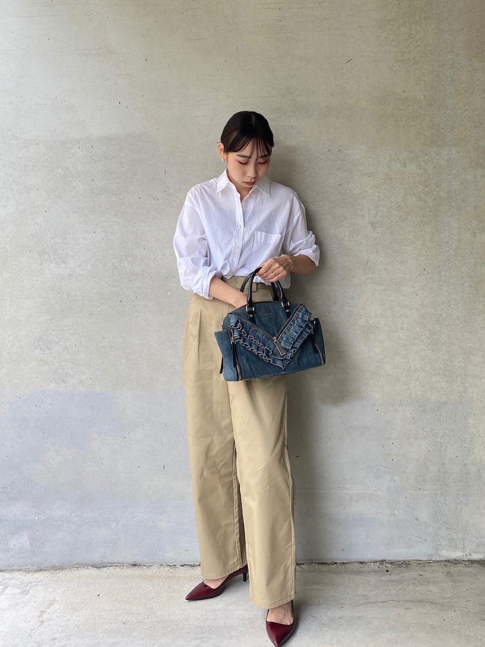 ホワイト系のシャツ/ブラウス、ブルー系のボストンバッグ、ベージュ系のチノパンツを着用したレディースの夏コーディネートの2枚目の写真