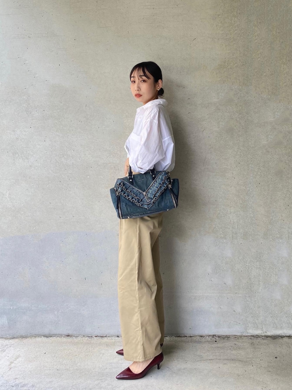 ホワイト系のシャツ/ブラウス、ブルー系のボストンバッグ、ベージュ系のチノパンツを着用したレディースの夏コーディネートの4枚目の写真