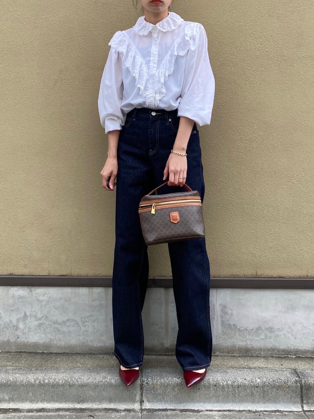 ブルー系のデニムパンツ、ブラウン系のバッグ、レッド系のパンプスを着用したレディースの夏コーディネートの5枚目の写真