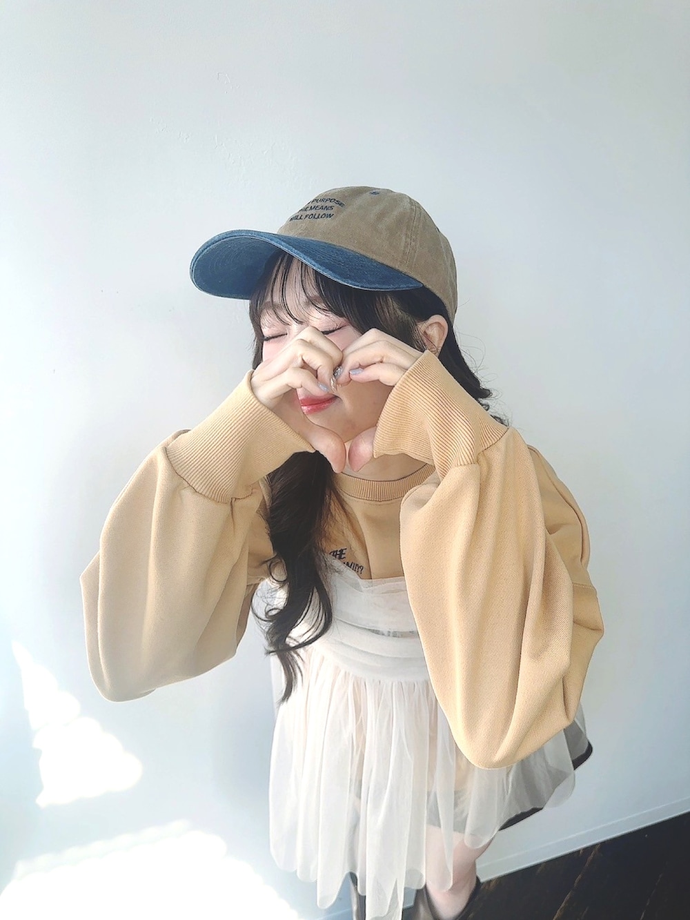 イエロー系のスウェット、グレー系のスウェット、シルバー系のキャミソールを着用したレディースの冬コーディネートの3枚目の写真