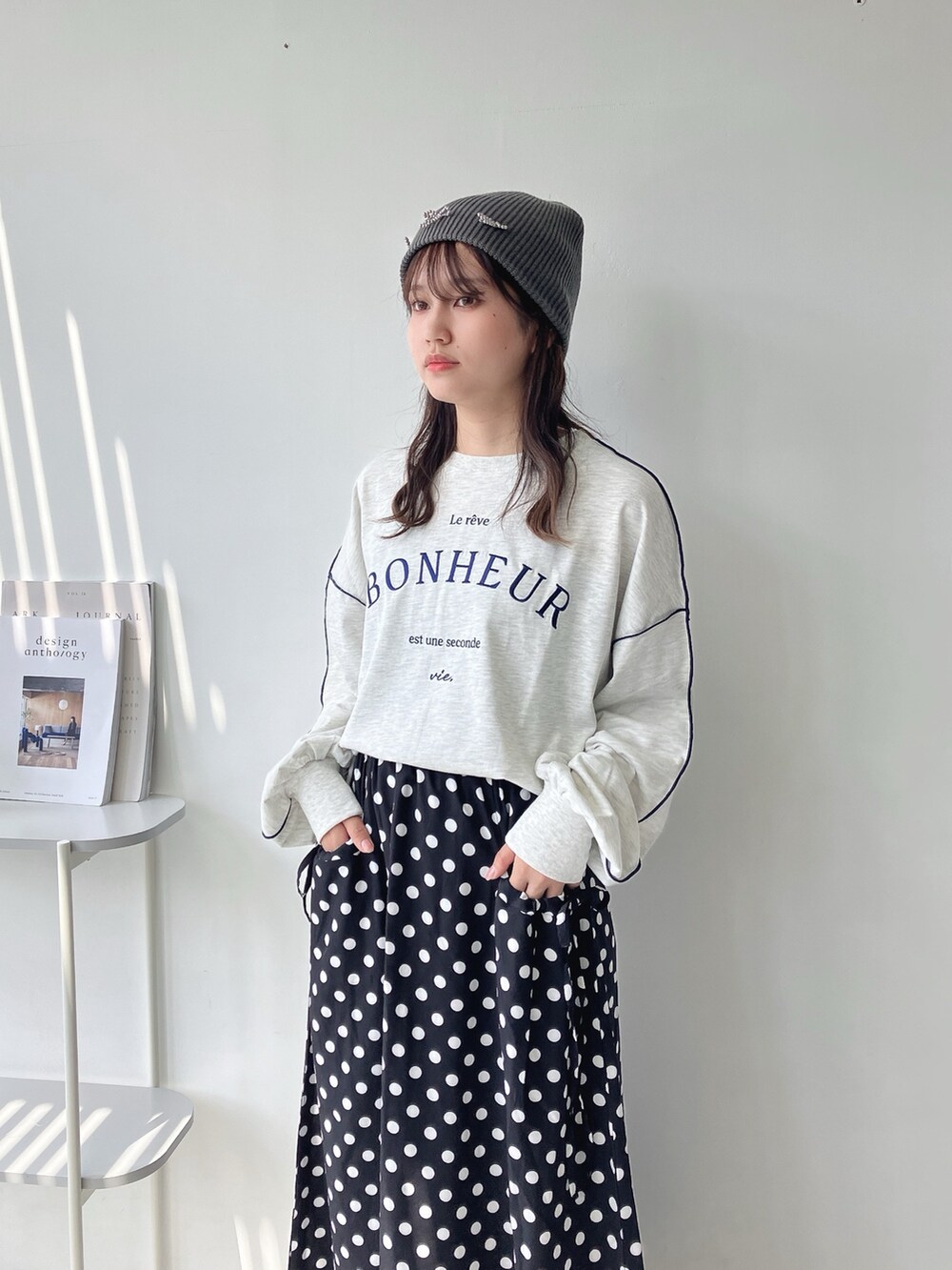 ブラック系のスカート、ベージュ系のTシャツ/カットソー、グレー系のニットキャップ/ビーニーを着用したレディースの秋コーディネートの2枚目の写真