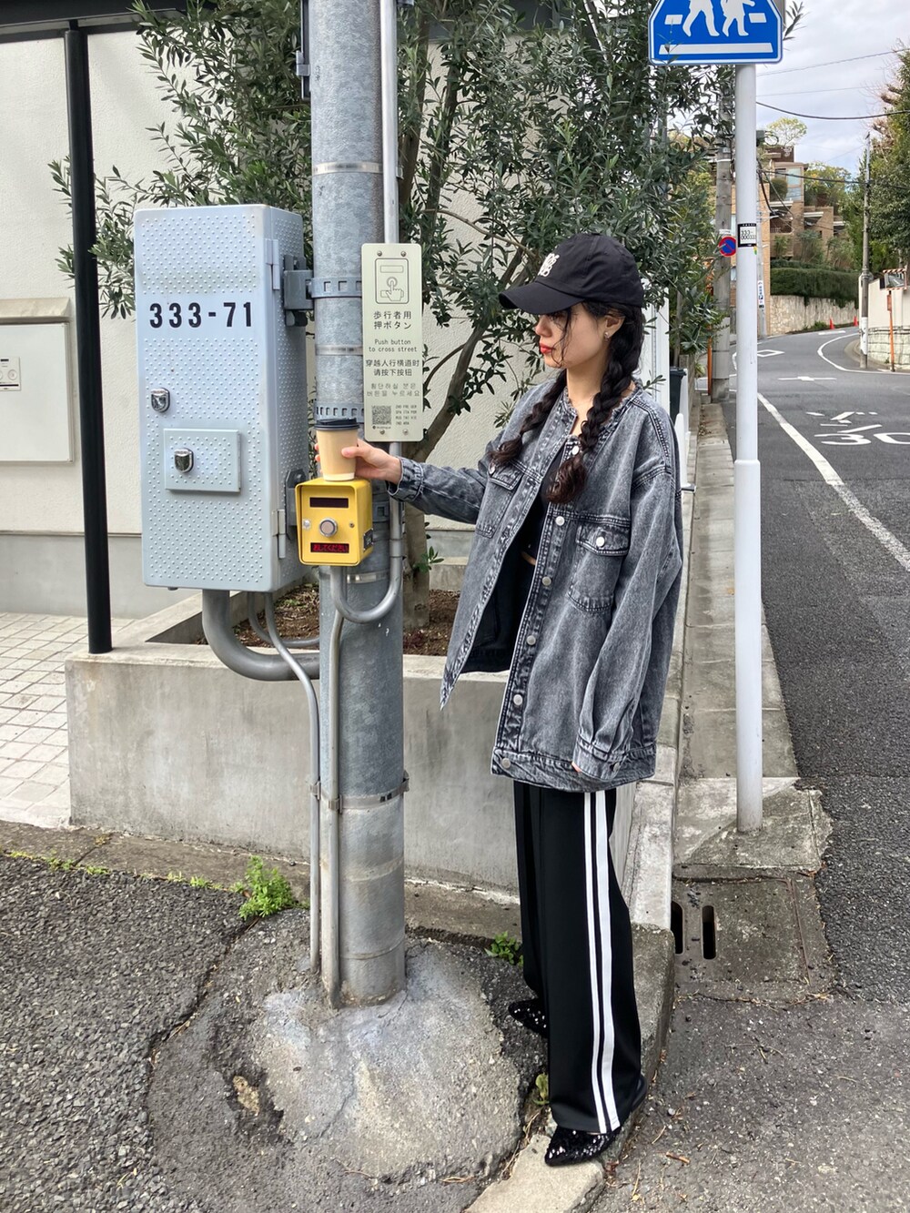 ブラック系のデニムジャケット、ブラック系のパンプス、ブラック系のキャミソールを着用したレディースの春コーディネートの2枚目の写真