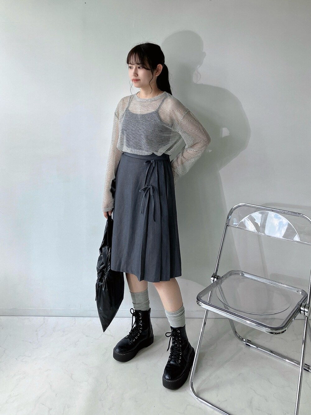 グレー系のスカート、ベージュ系のTシャツ/カットソー、ブラック系のキャミソールを着用したレディースの夏コーディネートの2枚目の写真