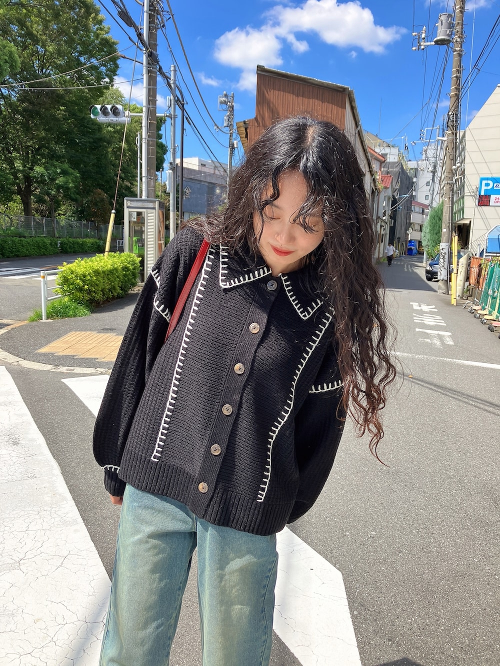 ブルー系のデニムパンツ、ブラック系のサンダル、ブラック系のカーディガン/ボレロを着用したレディースの秋コーディネートの3枚目の写真