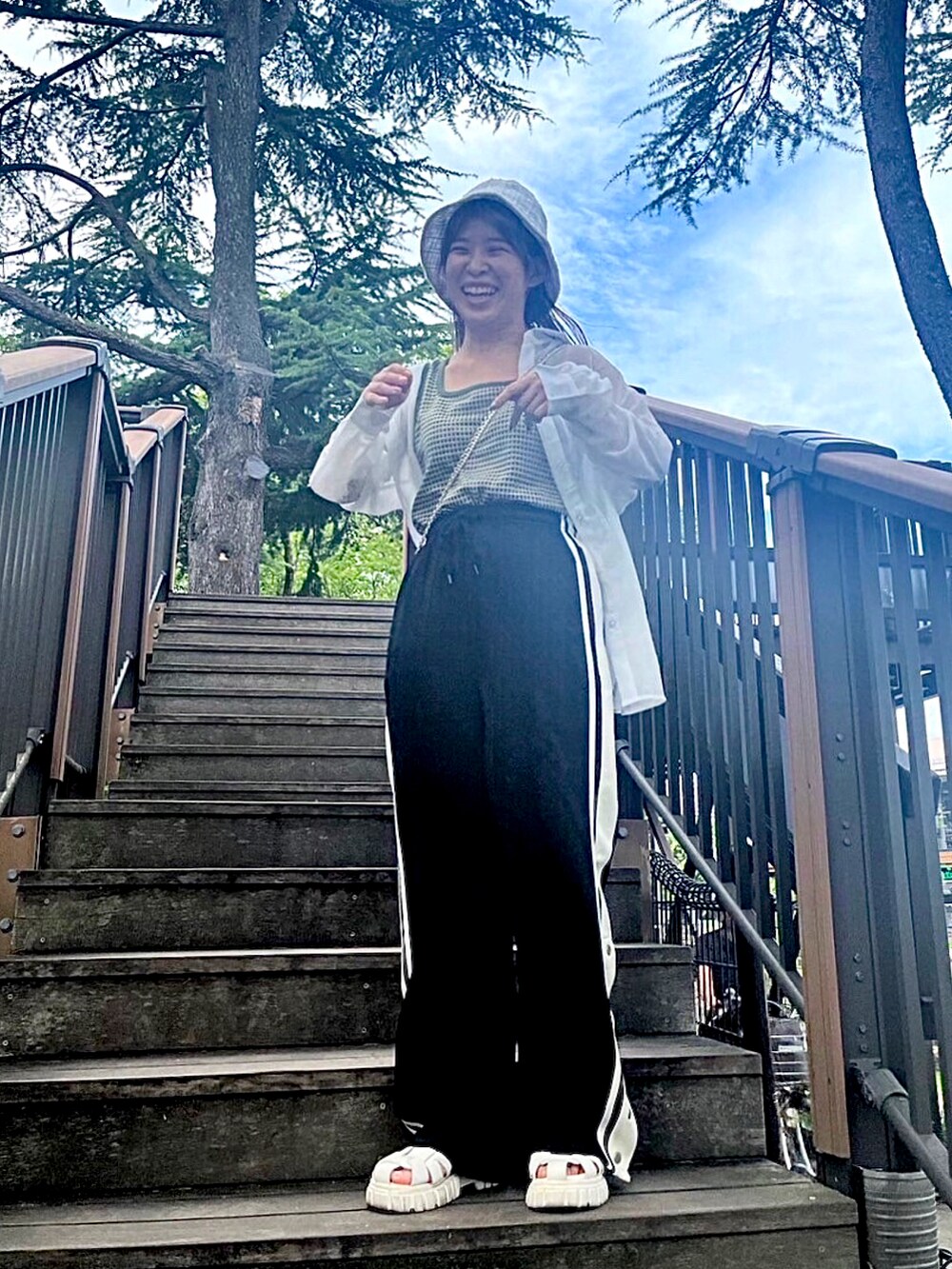 ホワイト系のその他パンツ、グリーン系のベストを着用したレディースの夏コーディネートの3枚目の写真