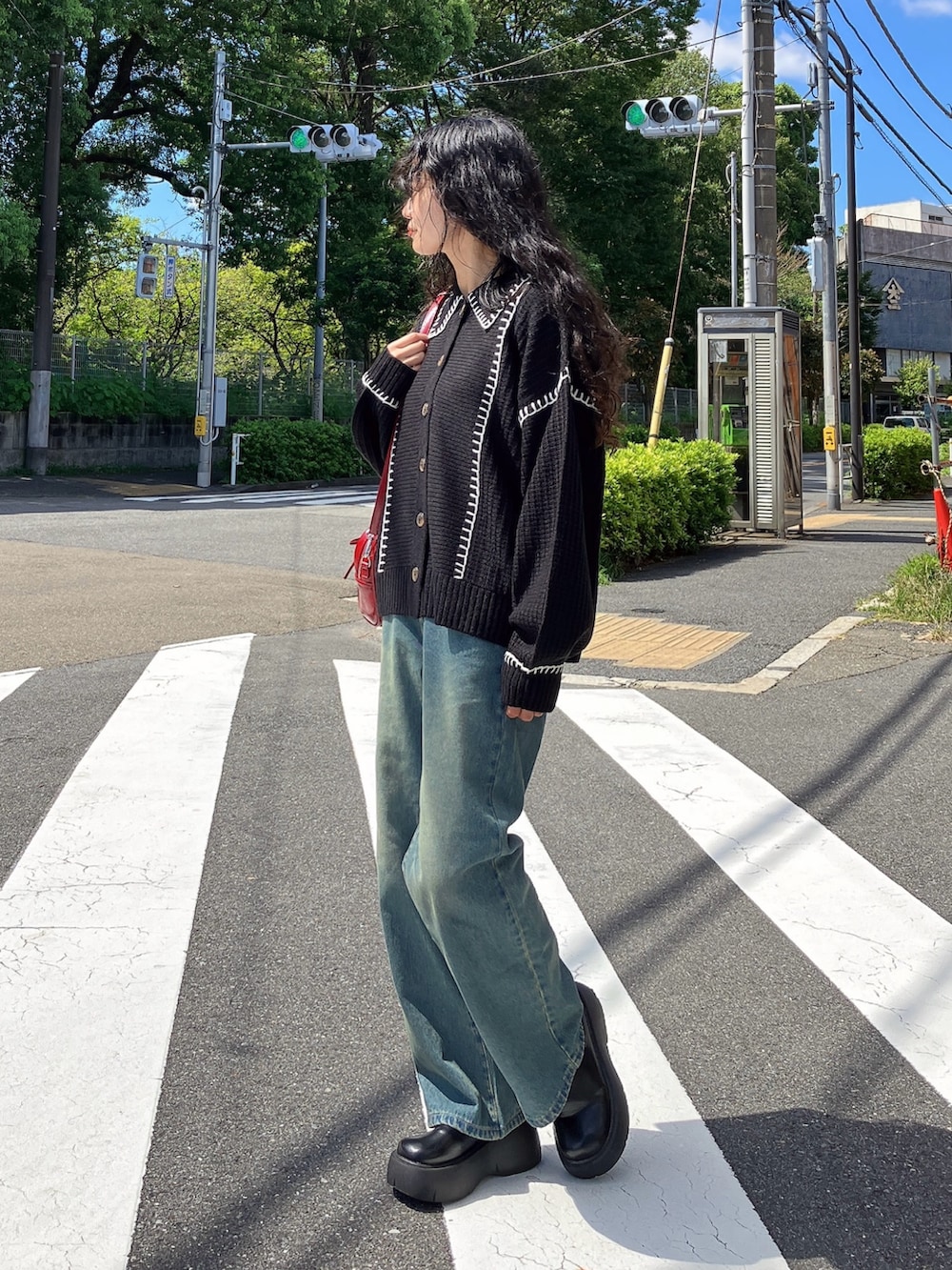 ブルー系のデニムパンツ、ブラック系のサンダル、ブラック系のカーディガン/ボレロを着用したレディースの秋コーディネートの2枚目の写真