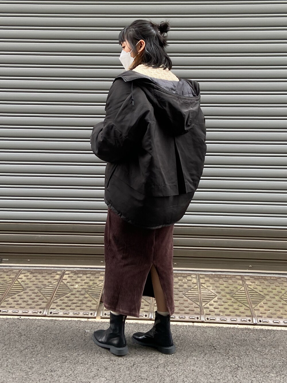 ベージュ系のニット/セーター、ブラック系のダウンジャケット/コート、ブラウン系のスカートを着用したレディースの冬コーディネートの2枚目の写真