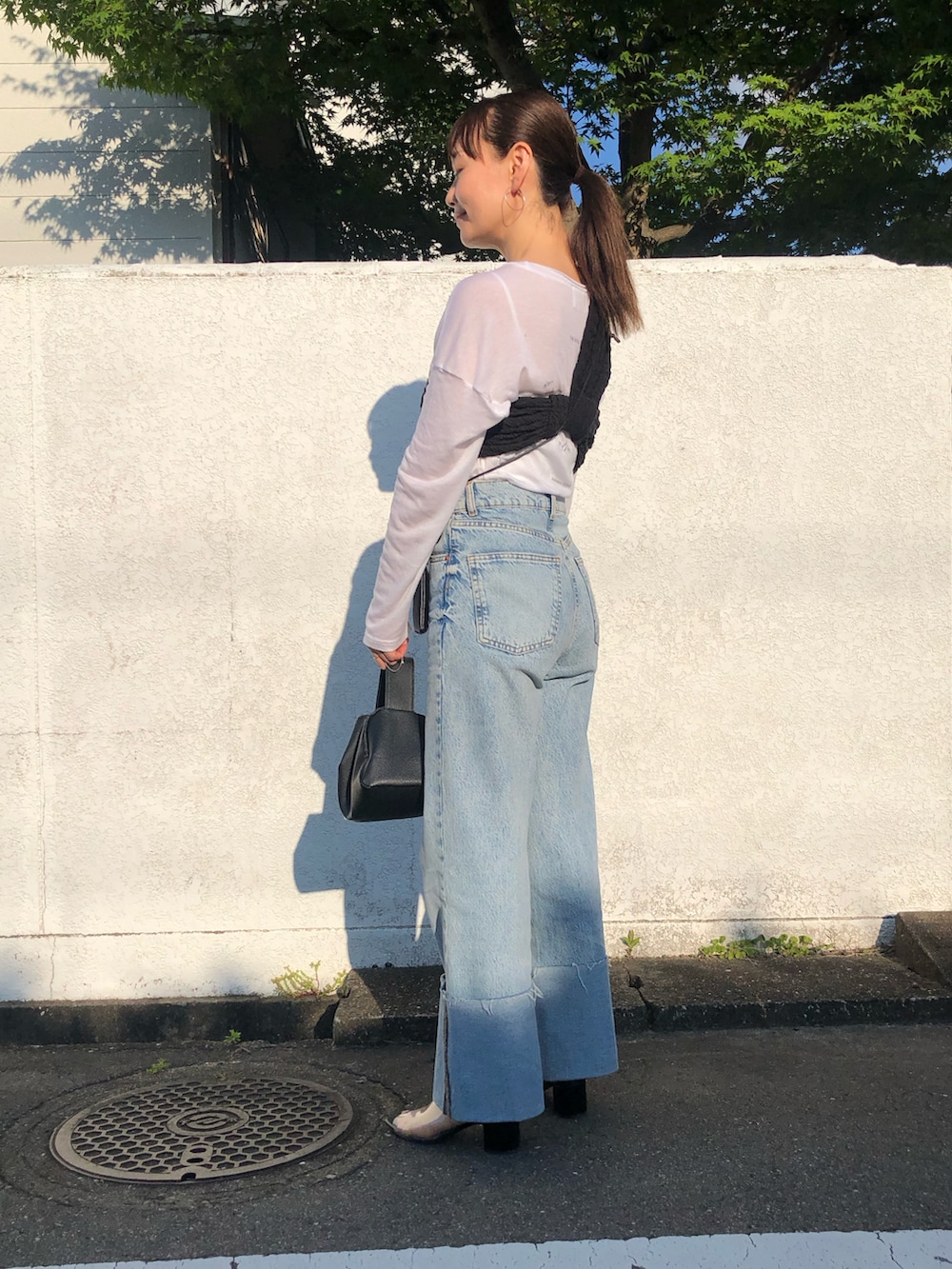 ブラック系のキャミソール、ブラック系のサンダル、ホワイト系のTシャツ/カットソーを着用したレディースの夏コーディネートの2枚目の写真