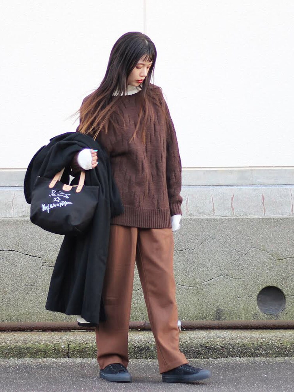 ブラック系のチェスターコート、ブラウン系のニット/セーター、ホワイト系のTシャツ/カットソーを着用したメンズの秋コーディネートの5枚目の写真