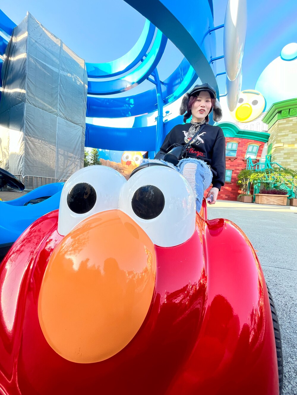 ブルー系のデニムパンツ、ブラック系のスウェット、ブラック系のバッグを着用したレディースの冬コーディネートの2枚目の写真