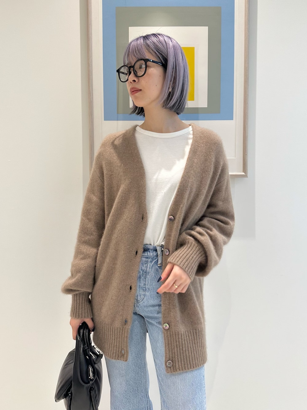 ブラウン系のカーディガン/ボレロ、ブラック系のハンドバッグ、ブラック系のブーツを着用したレディースの秋コーディネートの4枚目の写真