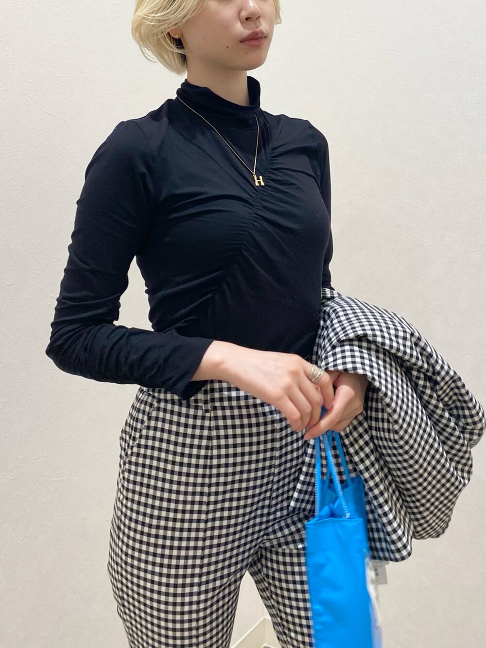 ブラック系のテーラードジャケット、ブラック系のその他パンツ、ブルー系のトートバッグを着用したレディースの冬コーディネートの4枚目の写真