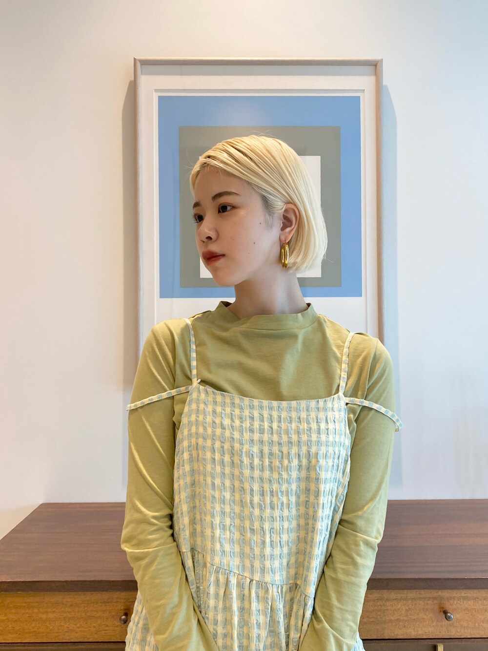 グリーン系のTシャツ/カットソー、イエロー系のワンピース、ホワイト系のボストンバッグを着用したレディースの春コーディネートの3枚目の写真