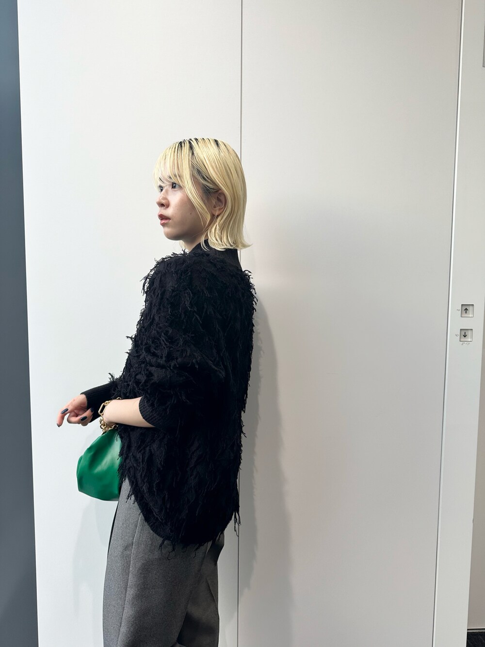 ブラック系のニット/セーター、グレー系のその他パンツ、グリーン系のハンドバッグを着用したレディースの秋コーディネートの4枚目の写真