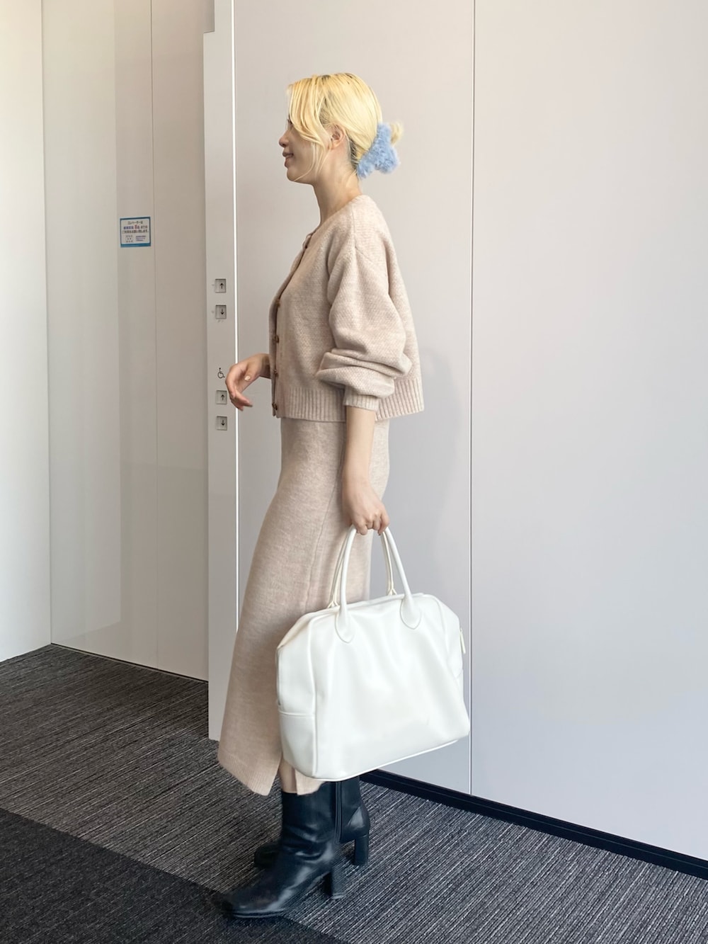 ベージュ系のワンピース、ホワイト系のボストンバッグ、ブラック系のブーツを着用したレディースの秋コーディネートの2枚目の写真