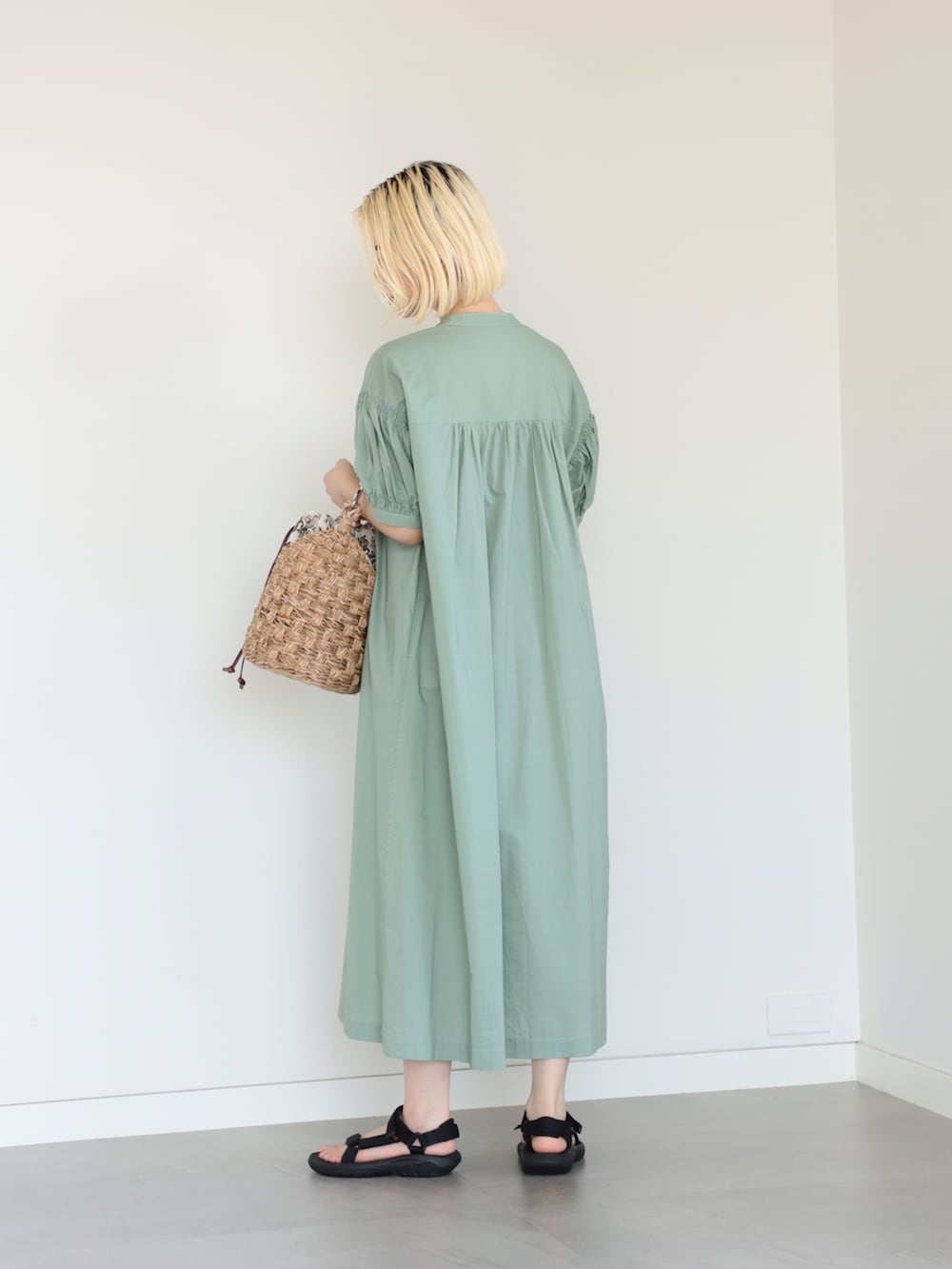 グリーン系のワンピースを着用したレディースの夏コーディネートの2枚目の写真