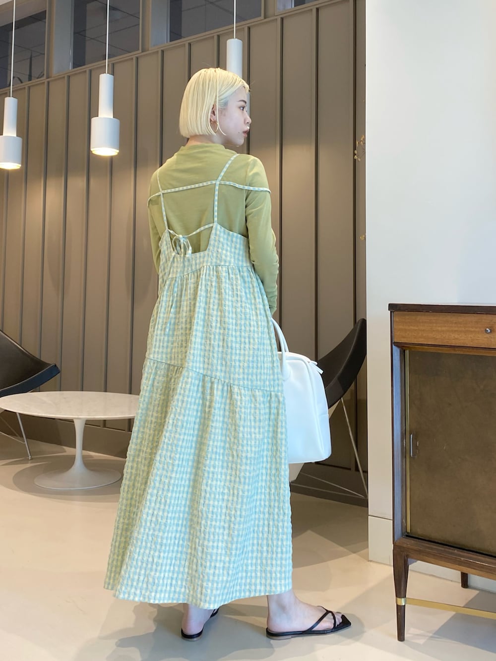 グリーン系のTシャツ/カットソー、イエロー系のワンピース、ホワイト系のボストンバッグを着用したレディースの春コーディネートの2枚目の写真