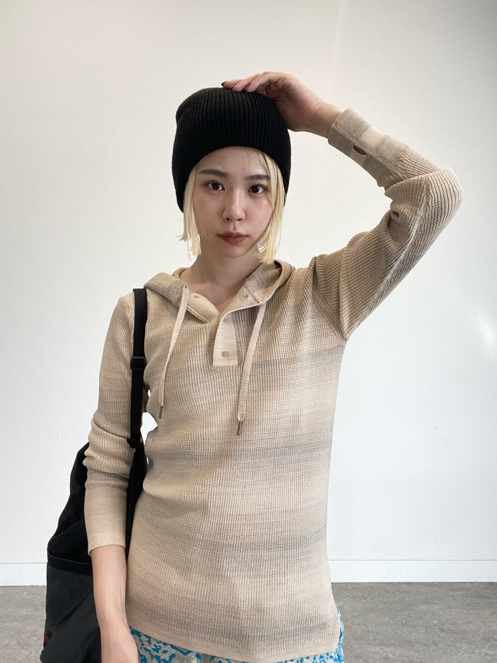 ベージュ系のパーカー、ブルー系のスカート、ブラック系のドレスシューズを着用したレディースの夏コーディネートの3枚目の写真