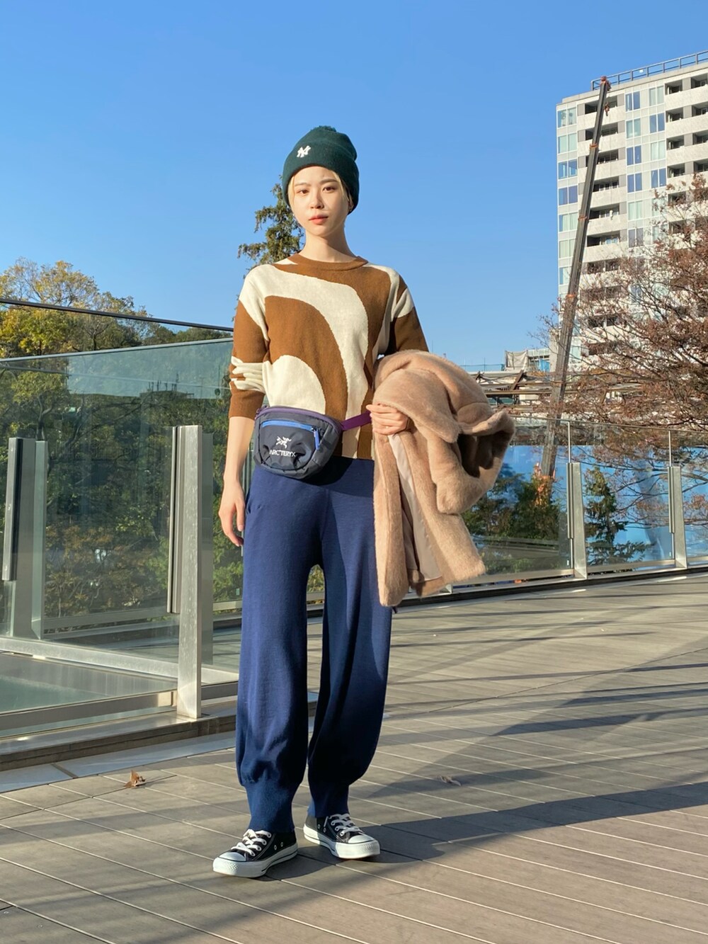 ベージュ系のその他アウター、ブラウン系のニット/セーター、ブルー系のボディバッグ/ウエストポーチを着用したレディースの冬コーディネートの4枚目の写真