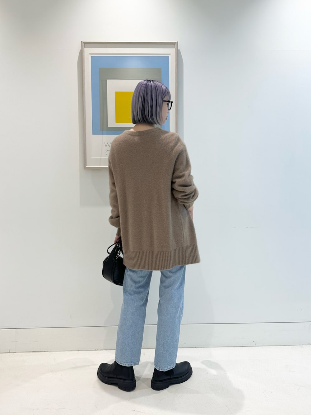 ブラウン系のカーディガン/ボレロ、ブラック系のハンドバッグ、ブラック系のブーツを着用したレディースの秋コーディネートの3枚目の写真