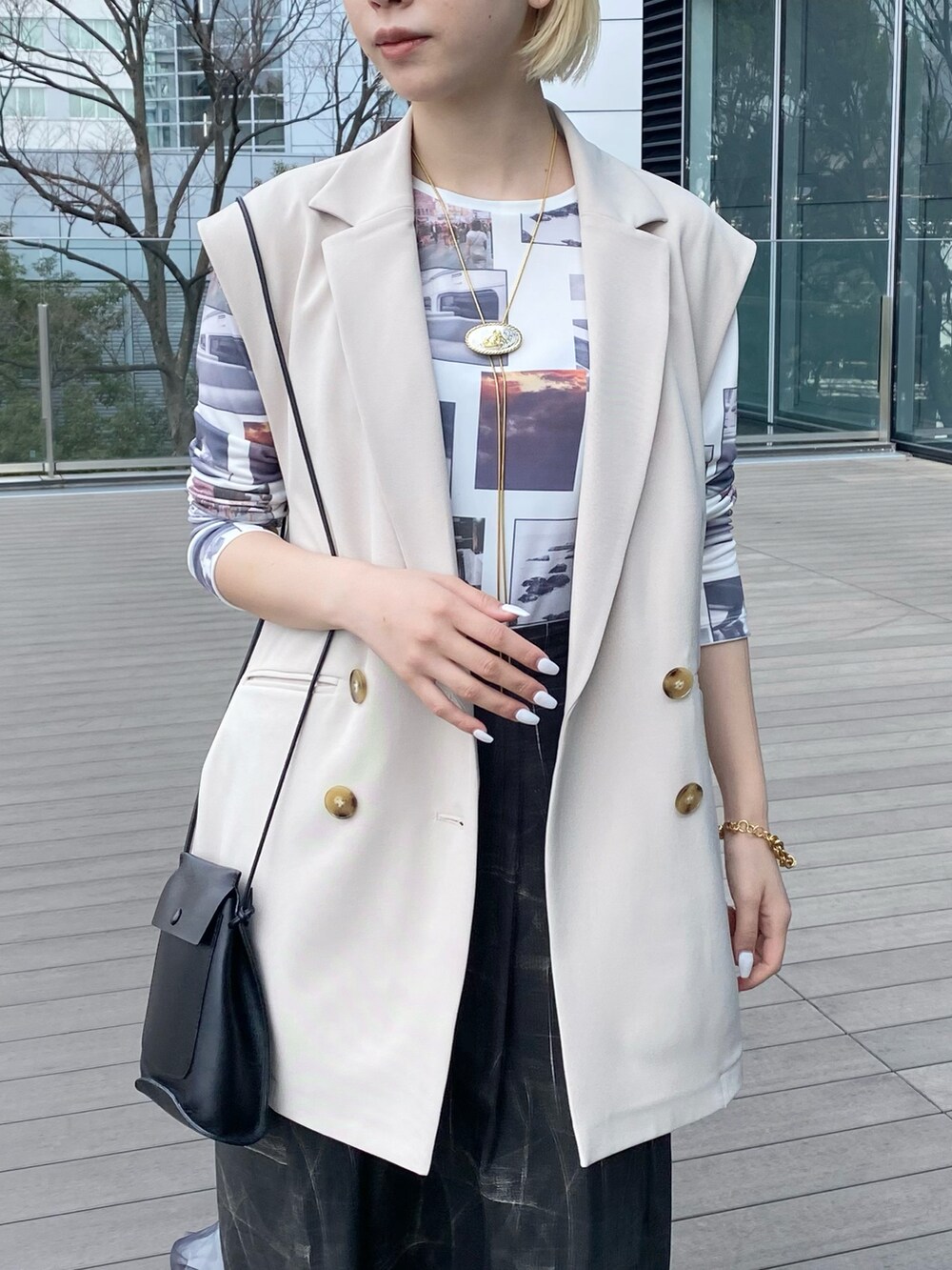 ホワイト系のTシャツ/カットソー、ホワイト系のベスト、ブラック系のショルダーバッグを着用したレディースの春コーディネートの2枚目の写真