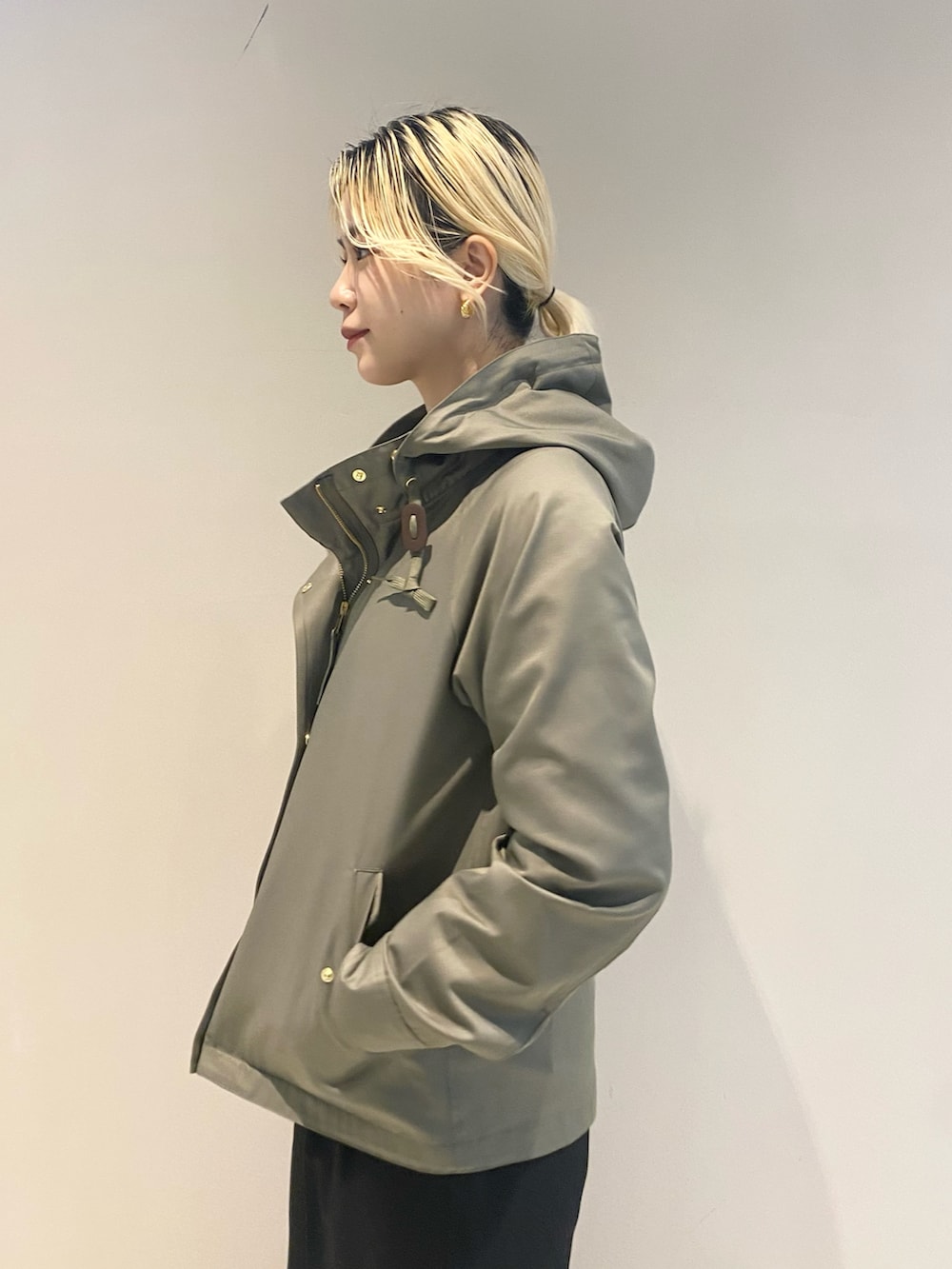 グリーン系のマウンテンパーカー、ベージュ系のニット/セーター、ブラック系のボストンバッグを着用したレディースの冬コーディネートの5枚目の写真
