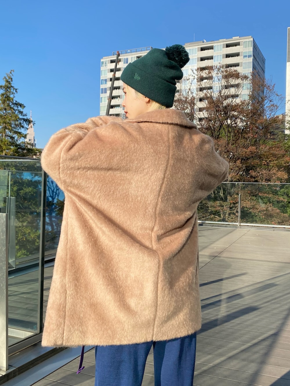 ベージュ系のその他アウター、ブラウン系のニット/セーター、ブルー系のボディバッグ/ウエストポーチを着用したレディースの冬コーディネートの3枚目の写真