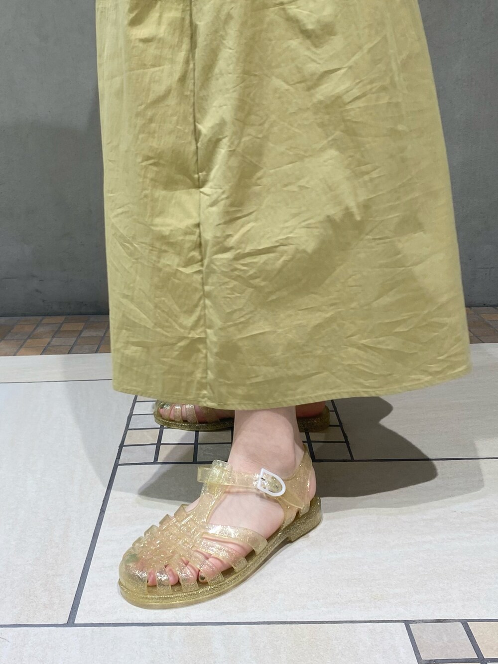 イエロー系のワンピース、ゴールド系のサンダルを着用したレディースの春コーディネートの4枚目の写真