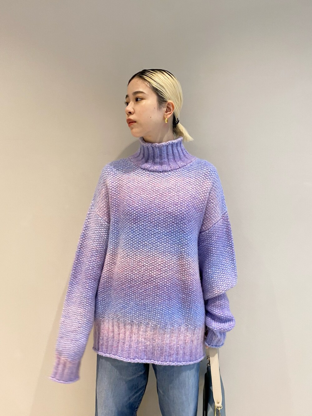 パープル系のニット/セーター、ブルー系のバッグ、シルバー系のパンプスを着用したレディースの秋コーディネートの3枚目の写真