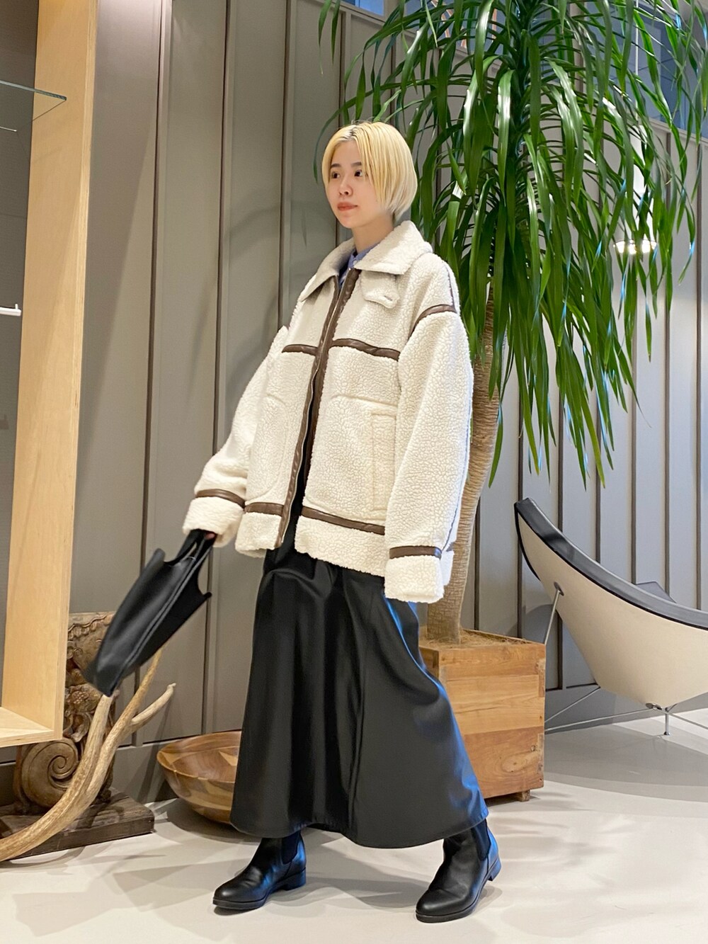ホワイト系のブルゾン、ブルー系のシャツ/ブラウス、ブラック系のワンピースを着用したレディースの冬コーディネートの2枚目の写真