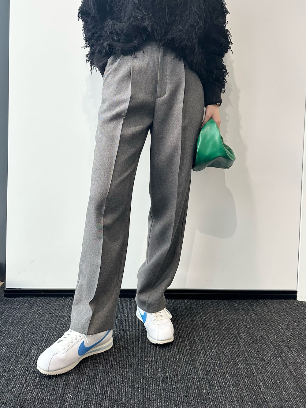 ブラック系のニット/セーター、グレー系のその他パンツ、グリーン系のハンドバッグを着用したレディースの秋コーディネートの5枚目の写真