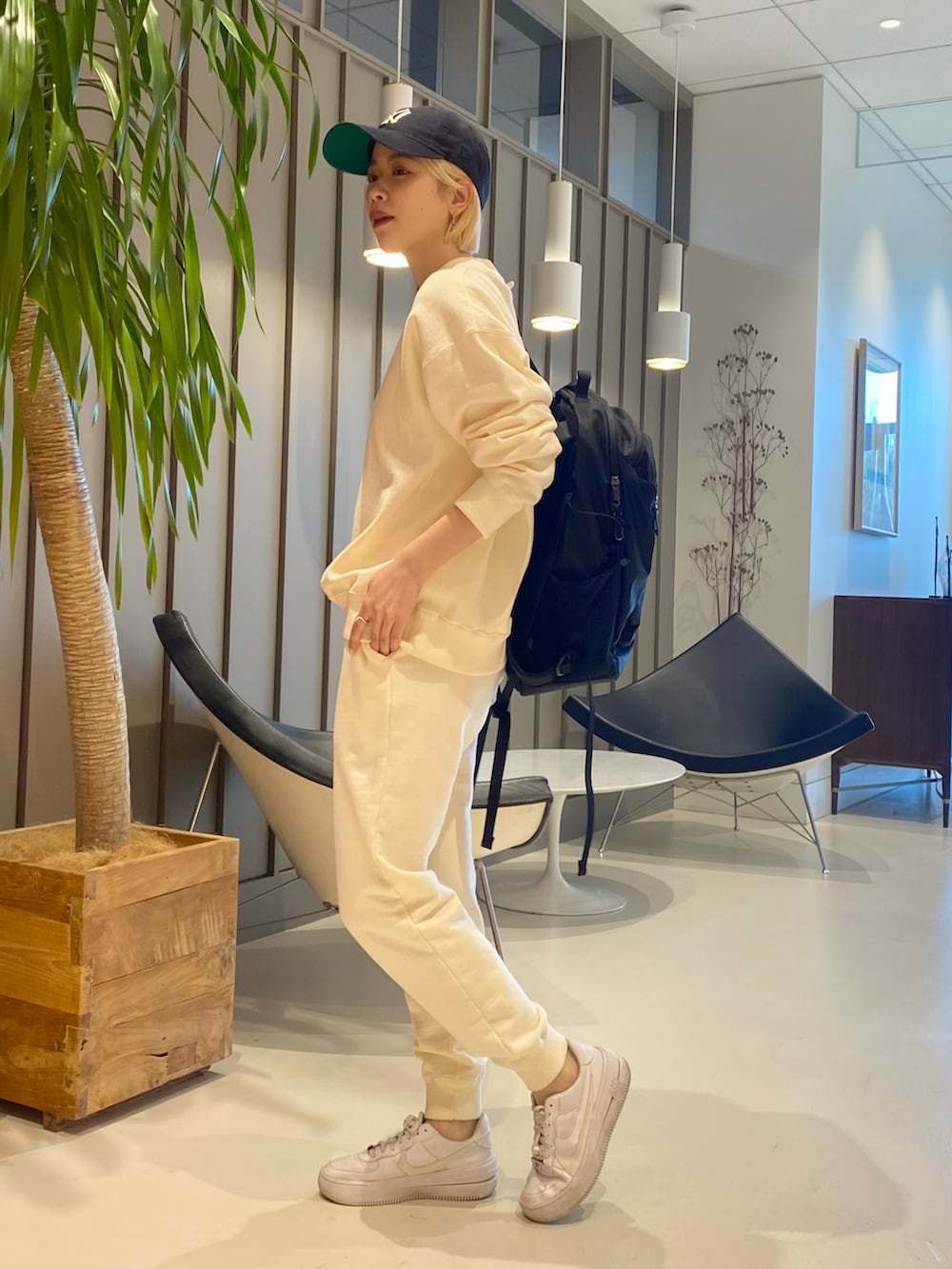 ホワイト系のスウェットパンツ、ホワイト系のスウェット、ブラック系のバックパック/リュックを着用したレディースの冬コーディネートの2枚目の写真