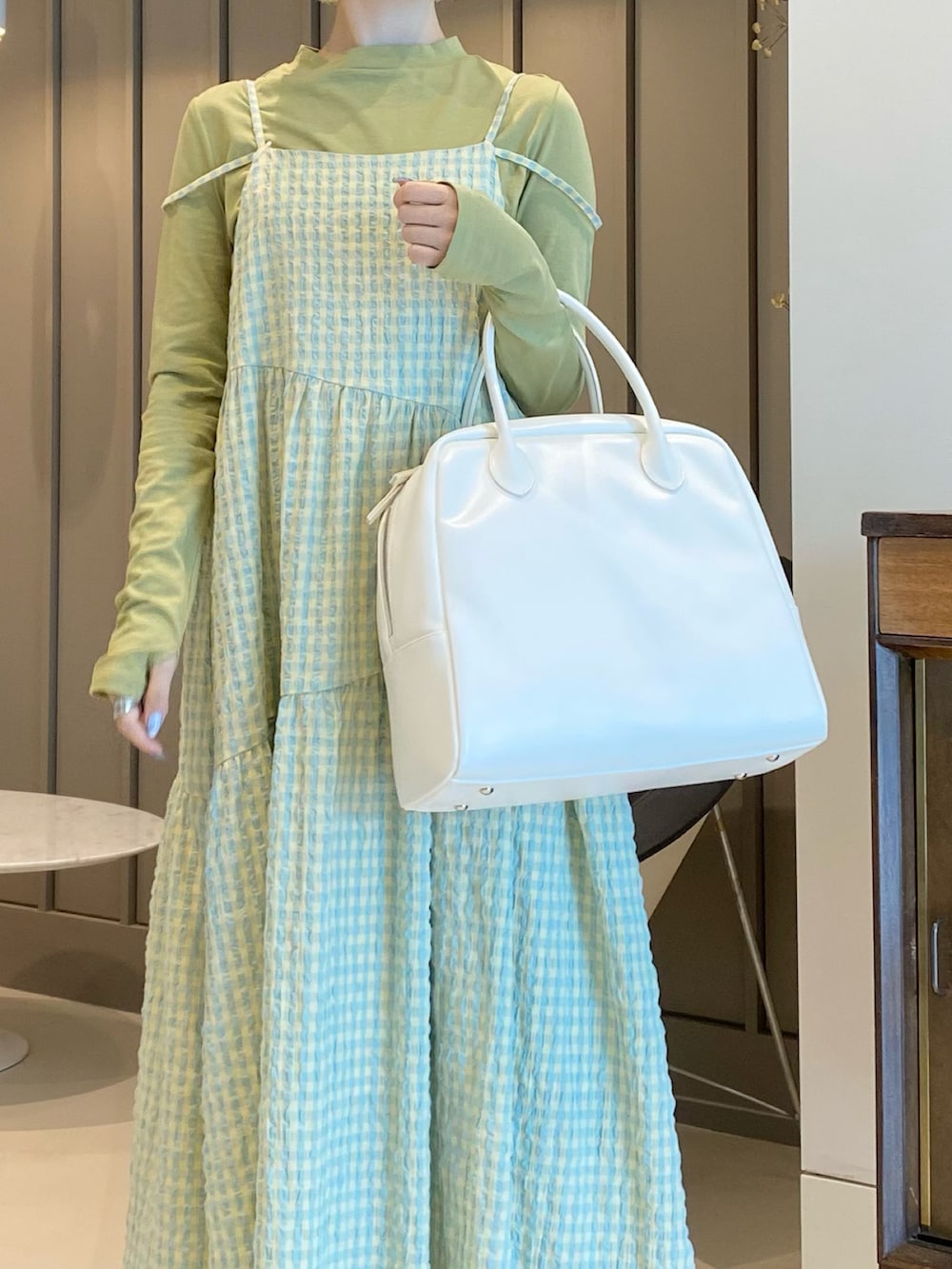 グリーン系のTシャツ/カットソー、イエロー系のワンピース、ホワイト系のボストンバッグを着用したレディースの春コーディネートの5枚目の写真