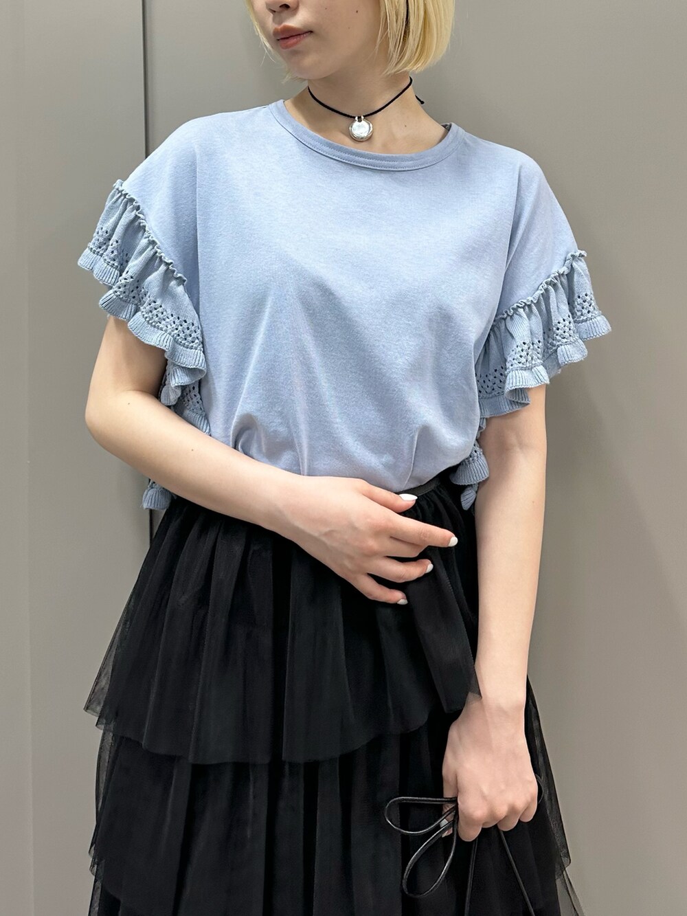 ブルー系のTシャツ/カットソー、ブラック系のスカート、シルバー系のパンプスを着用したレディースの春コーディネートの2枚目の写真