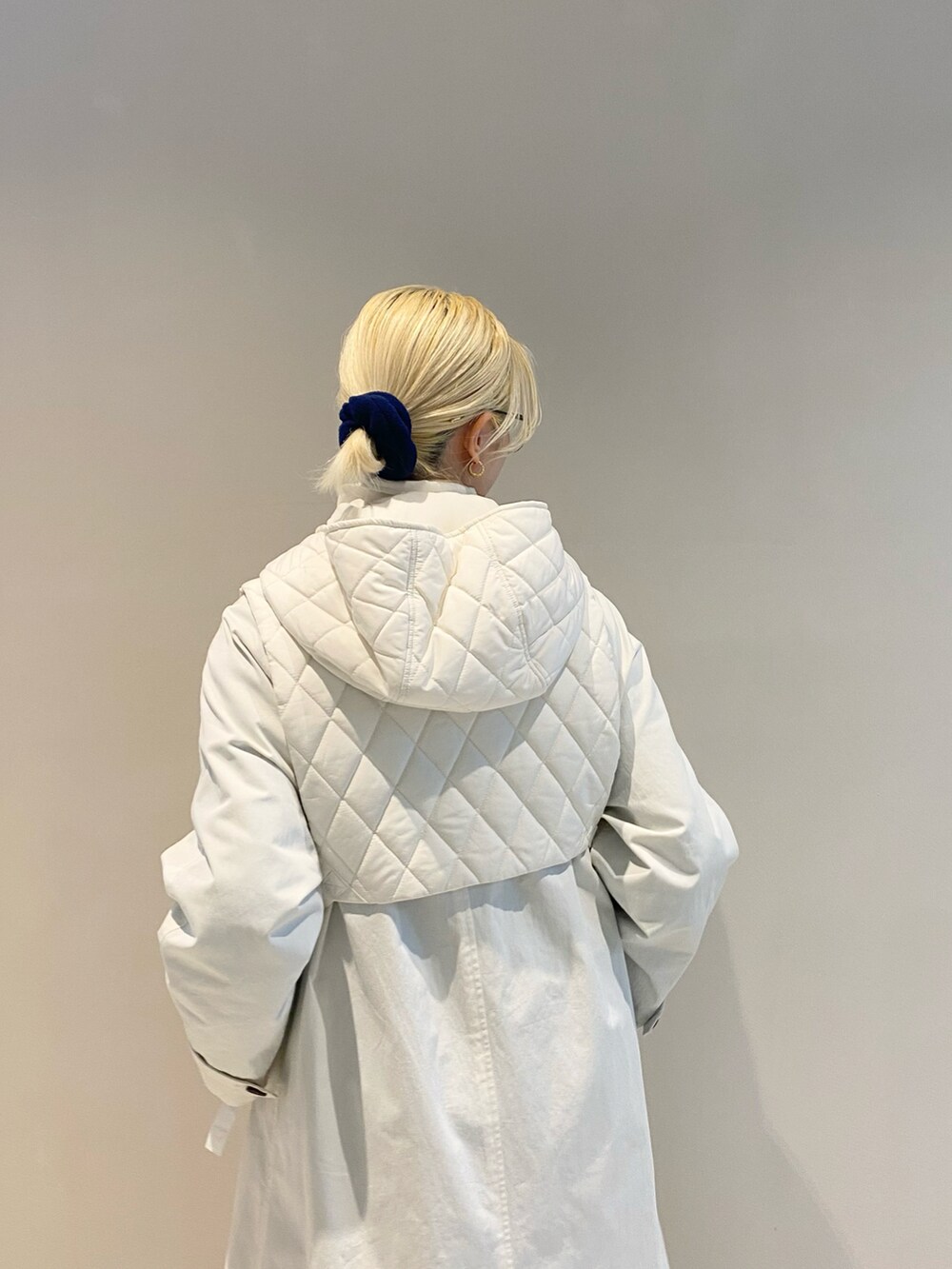 ホワイト系のその他アウター、ホワイト系のスニーカー、ブルー系のニット/セーターを着用したレディースの秋コーディネートの3枚目の写真