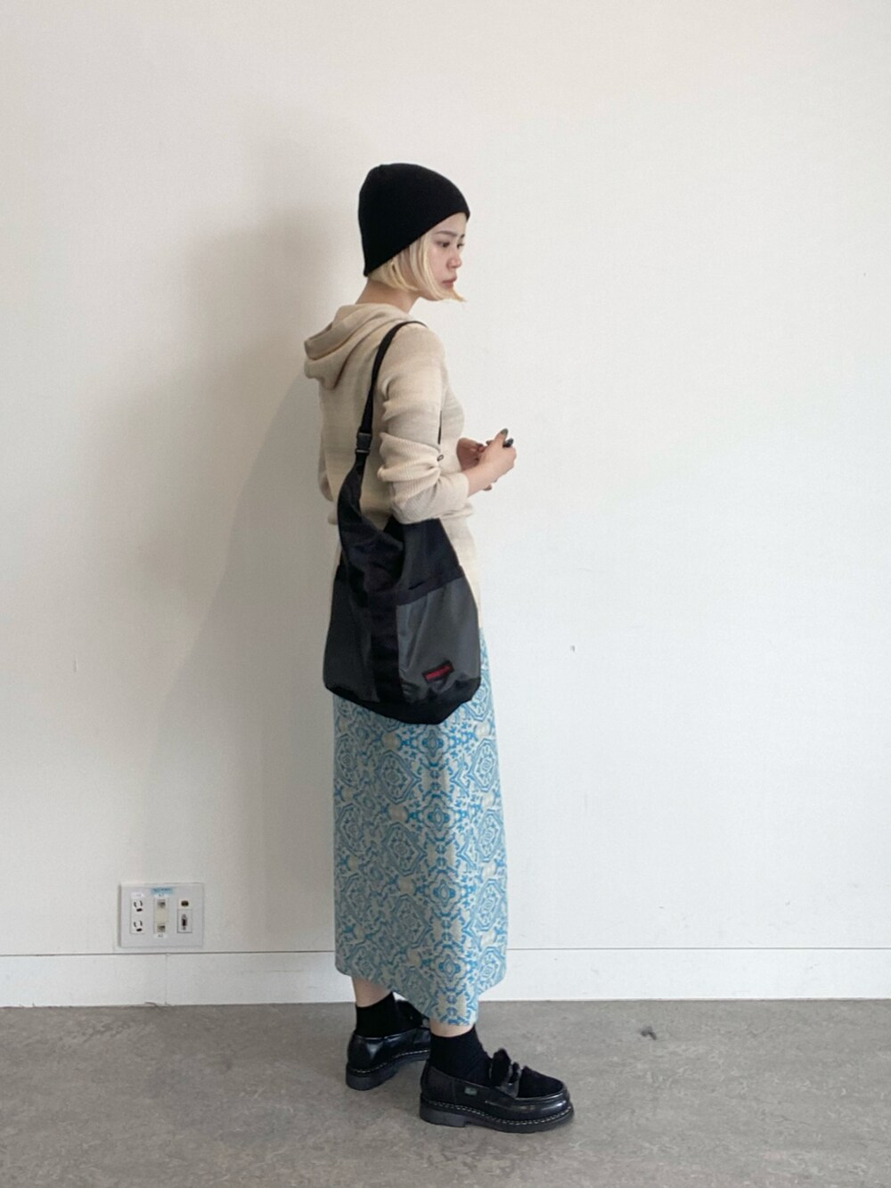 ベージュ系のパーカー、ブルー系のスカート、ブラック系のドレスシューズを着用したレディースの夏コーディネートの2枚目の写真