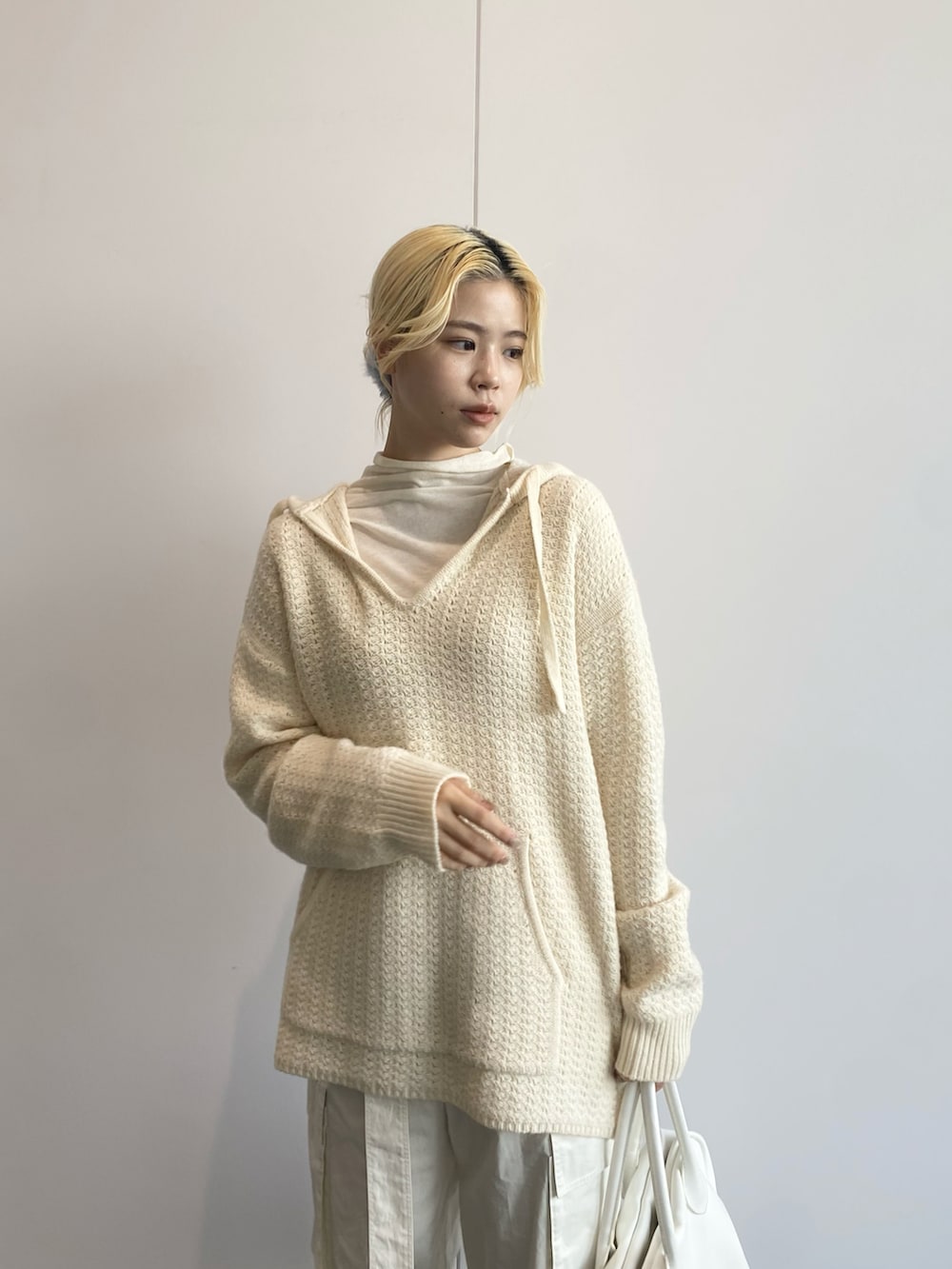 ホワイト系のTシャツ/カットソー、ホワイト系のニット/セーター、ホワイト系のカーゴパンツを着用したレディースの秋コーディネートの3枚目の写真