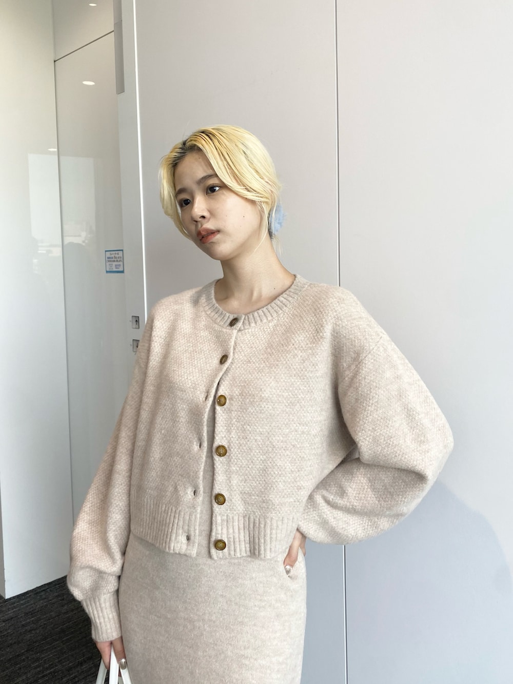 ベージュ系のワンピース、ホワイト系のボストンバッグ、ブラック系のブーツを着用したレディースの秋コーディネートの3枚目の写真