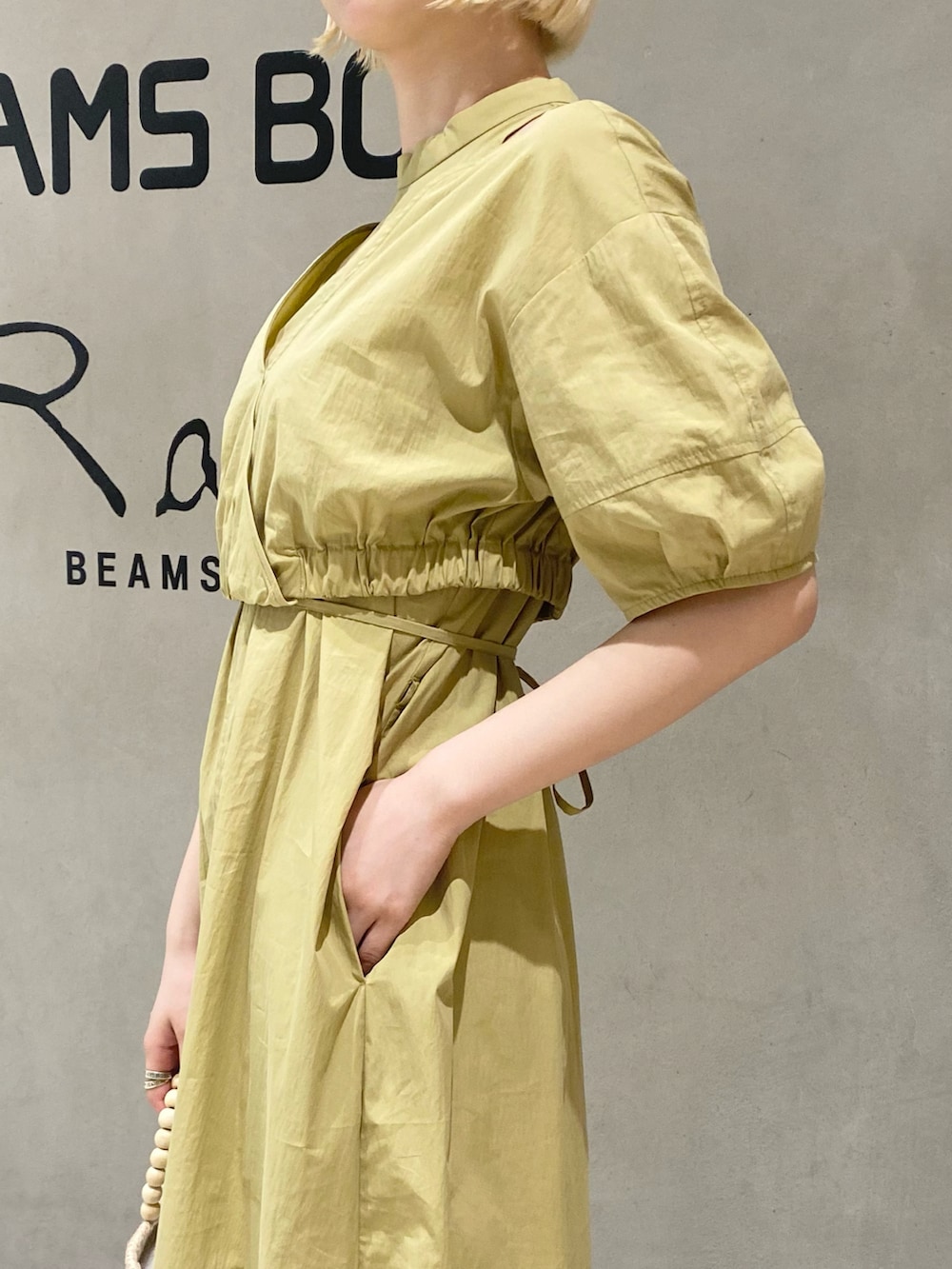 イエロー系のワンピース、ゴールド系のサンダルを着用したレディースの春コーディネートの3枚目の写真