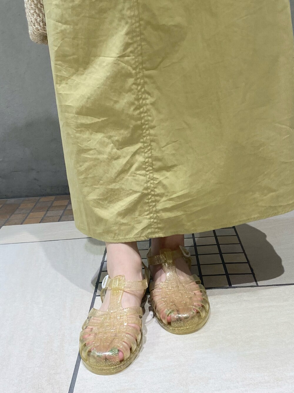 イエロー系のワンピース、ゴールド系のサンダルを着用したレディースの春コーディネートの5枚目の写真