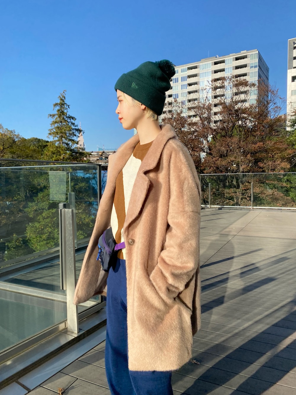 ベージュ系のその他アウター、ブラウン系のニット/セーター、ブルー系のボディバッグ/ウエストポーチを着用したレディースの冬コーディネートの2枚目の写真