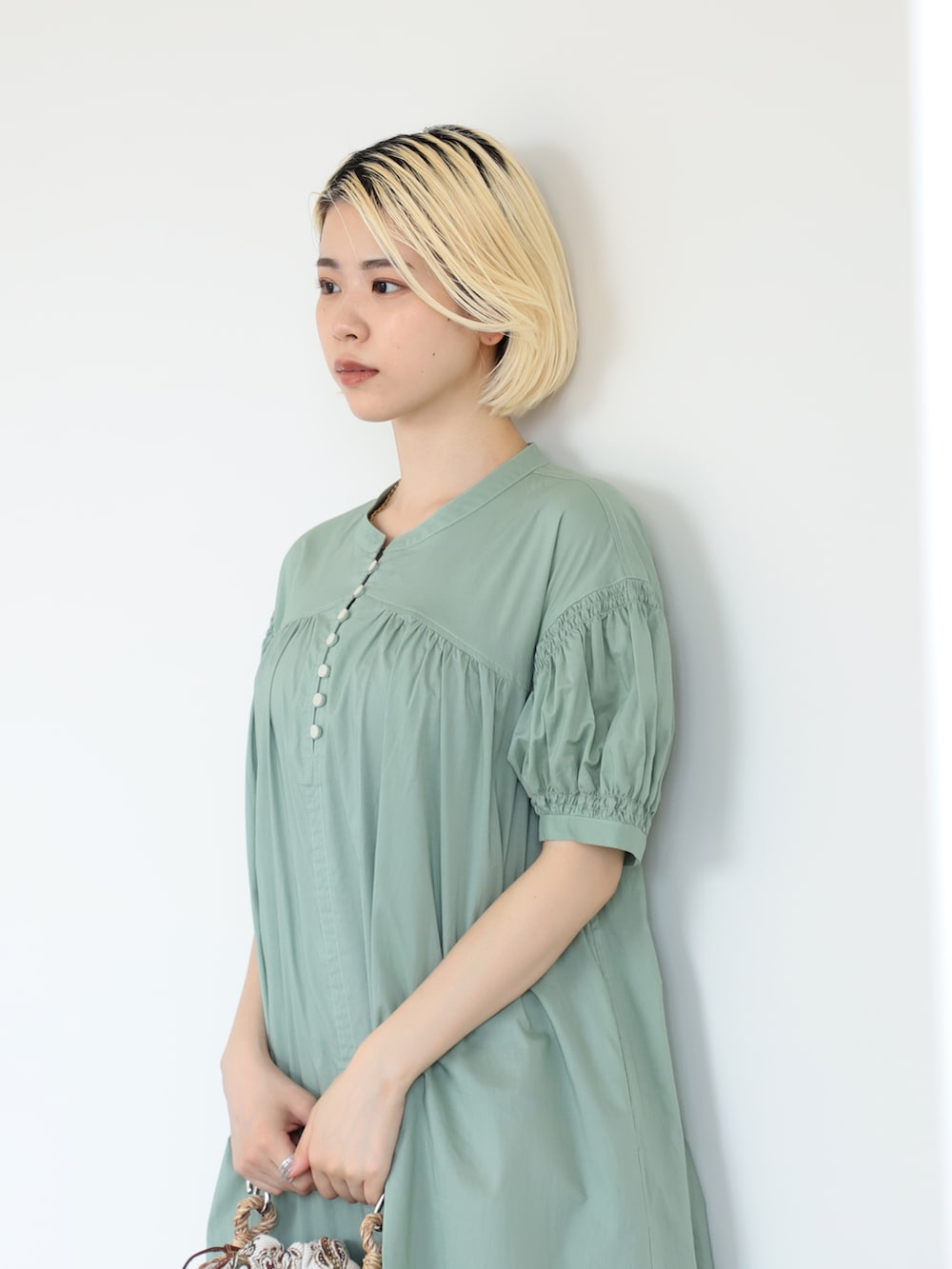 グリーン系のワンピースを着用したレディースの夏コーディネートの3枚目の写真