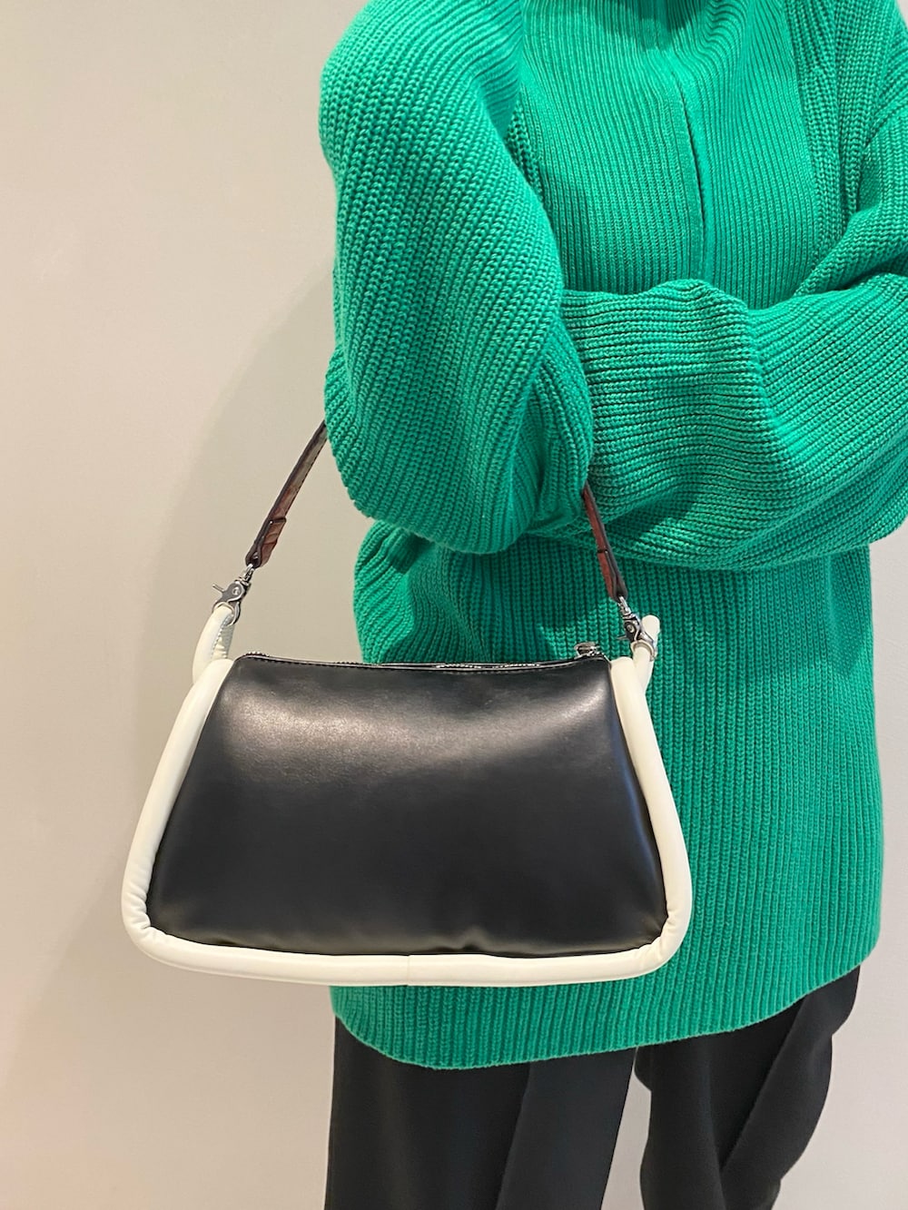 グリーン系のニット/セーター、ブラック系のショルダーバッグ、ブラック系のスラックスを着用したレディースの冬コーディネートの4枚目の写真