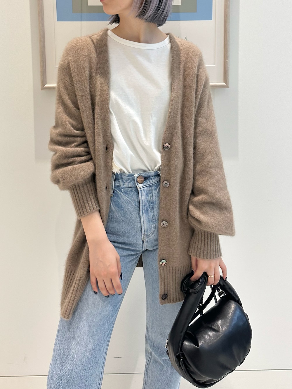 ブラウン系のカーディガン/ボレロ、ブラック系のハンドバッグ、ブラック系のブーツを着用したレディースの秋コーディネートの5枚目の写真