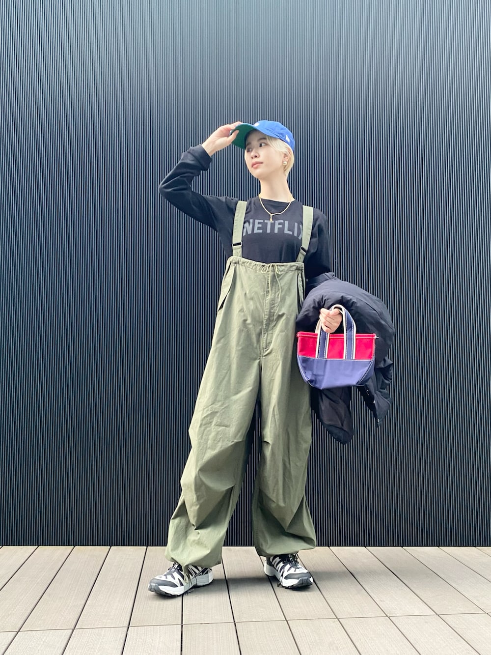 ブラック系のTシャツ/カットソー、グリーン系のサロペット/オーバーオール、レッド系のトートバッグを着用したレディースの冬コーディネートの2枚目の写真