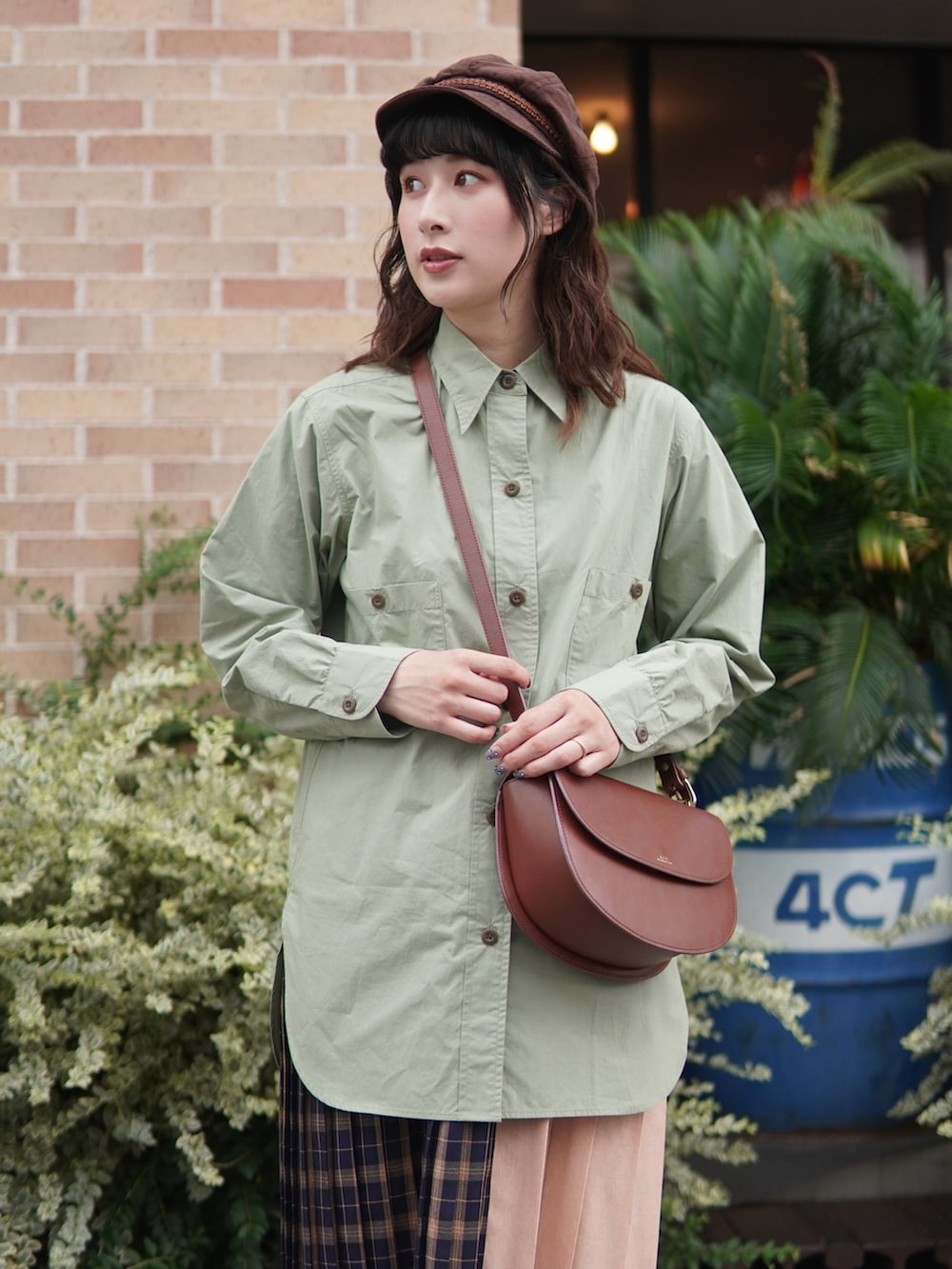 グリーン系のシャツ/ブラウス、ブルー系のスカート、ブラウン系のショルダーバッグを着用したレディースの秋コーディネートの3枚目の写真