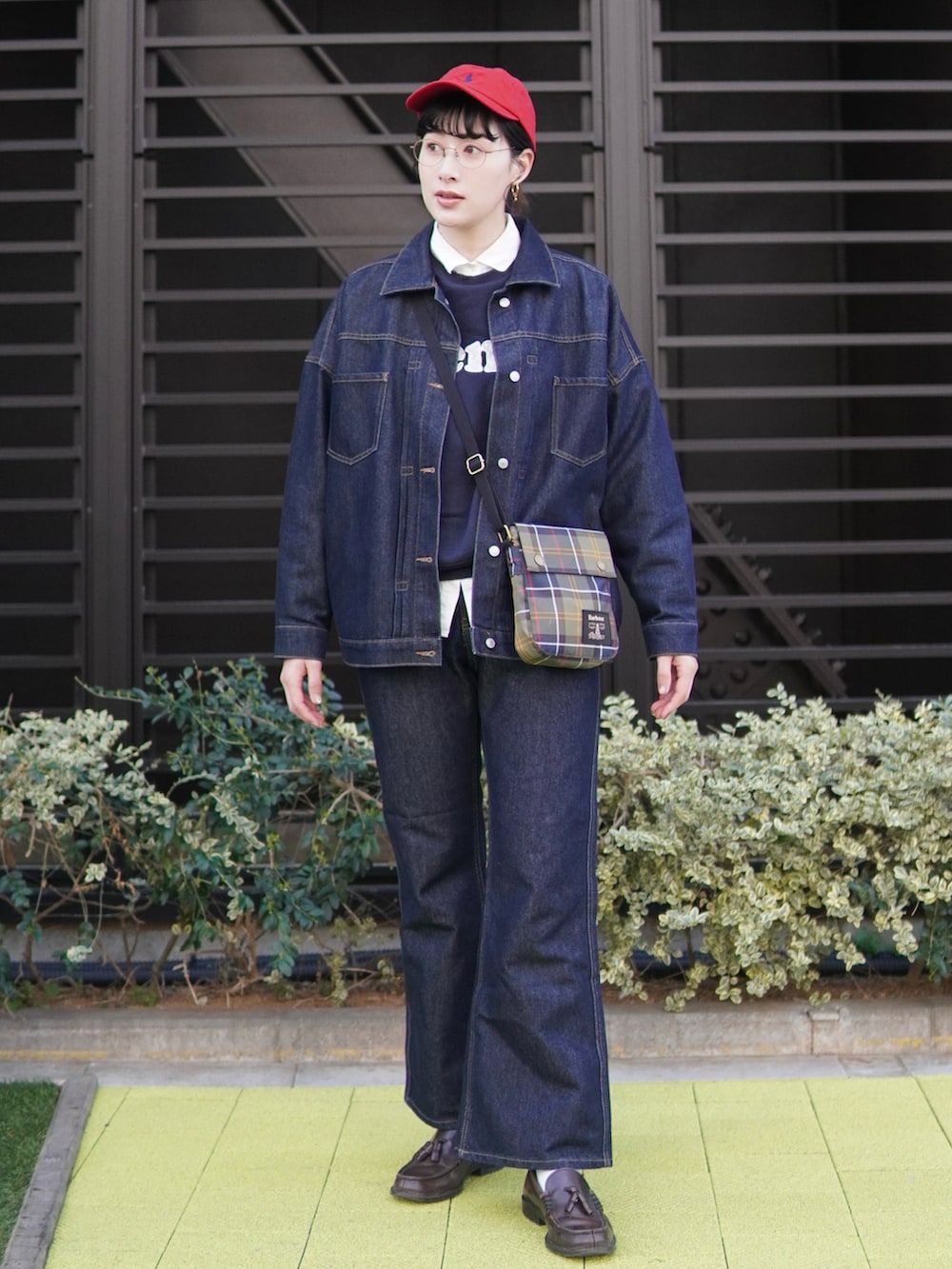 ブルー系のデニムパンツ、ブルー系のデニムジャケット、ブラウン系のローファーを着用したレディースの春コーディネートの2枚目の写真