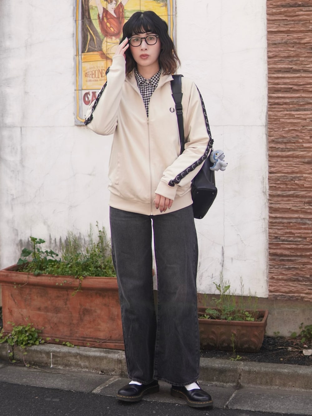 ブラック系のデニムパンツ、ホワイト系のジャージ、ブラック系のトートバッグを着用したレディースの春コーディネートの2枚目の写真